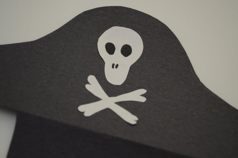 Cut out a skull and two bones from white construction paper